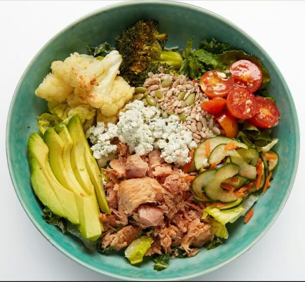 California Cobb Salad Smoked chicken, avocado, roasted cauliflower, cucumber namasu, roasted broccoli, marinated cherry tomatoes, blue cheese crumbles, seed blend, your choice of grains with our greens blend and Greek dressing (served on side).